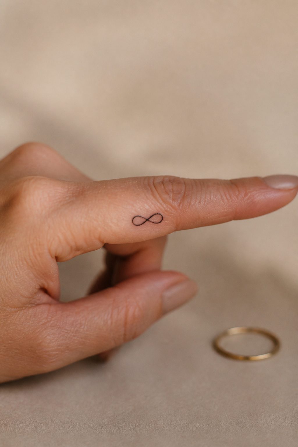 10 Dainty Tattoo Ideas for Women: Butterflies to Geometric Ink 8 Infinity symbol tattoo displayed on skin.