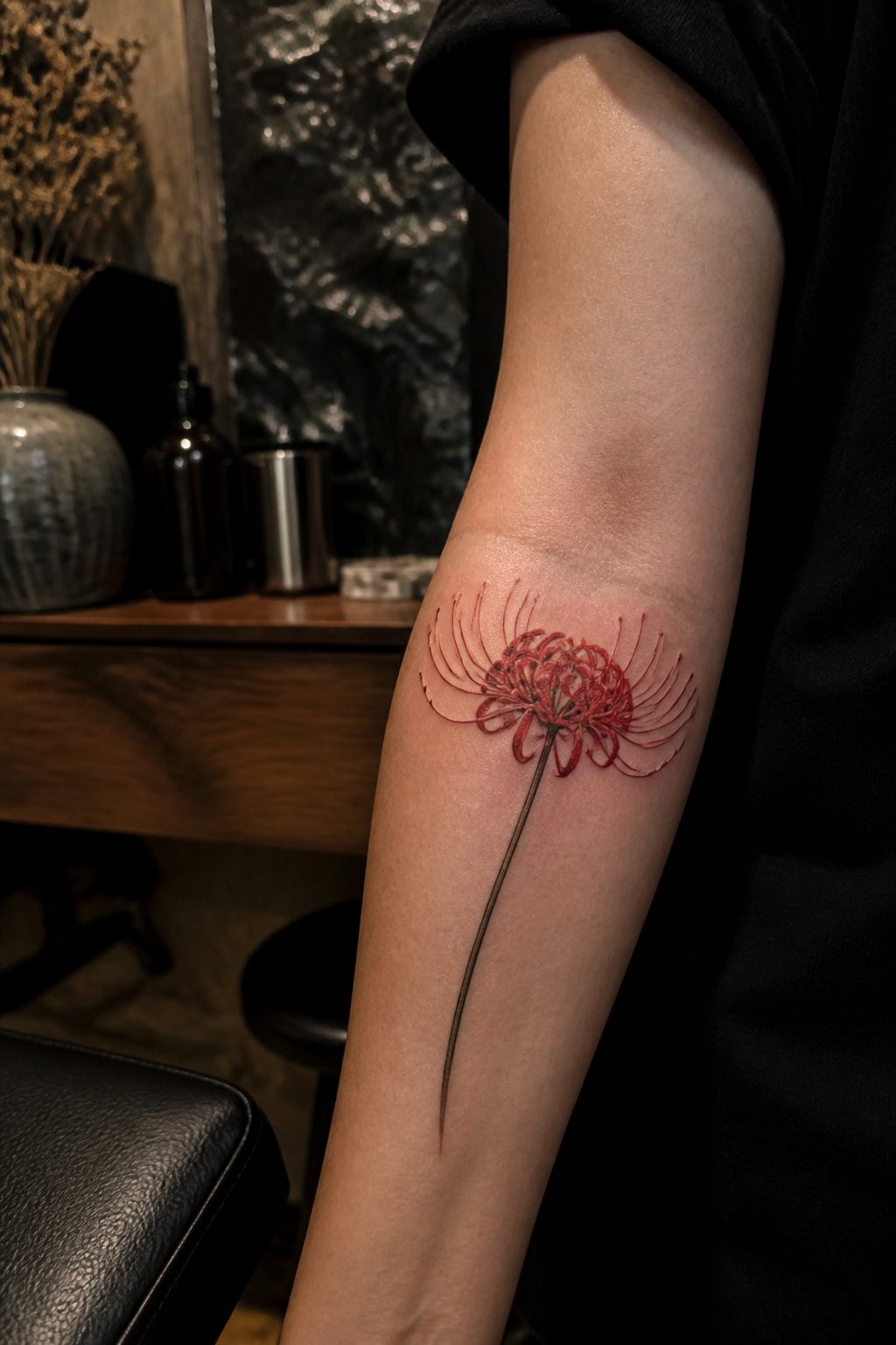 Tattoo design of a red spider lily with curling stamens.