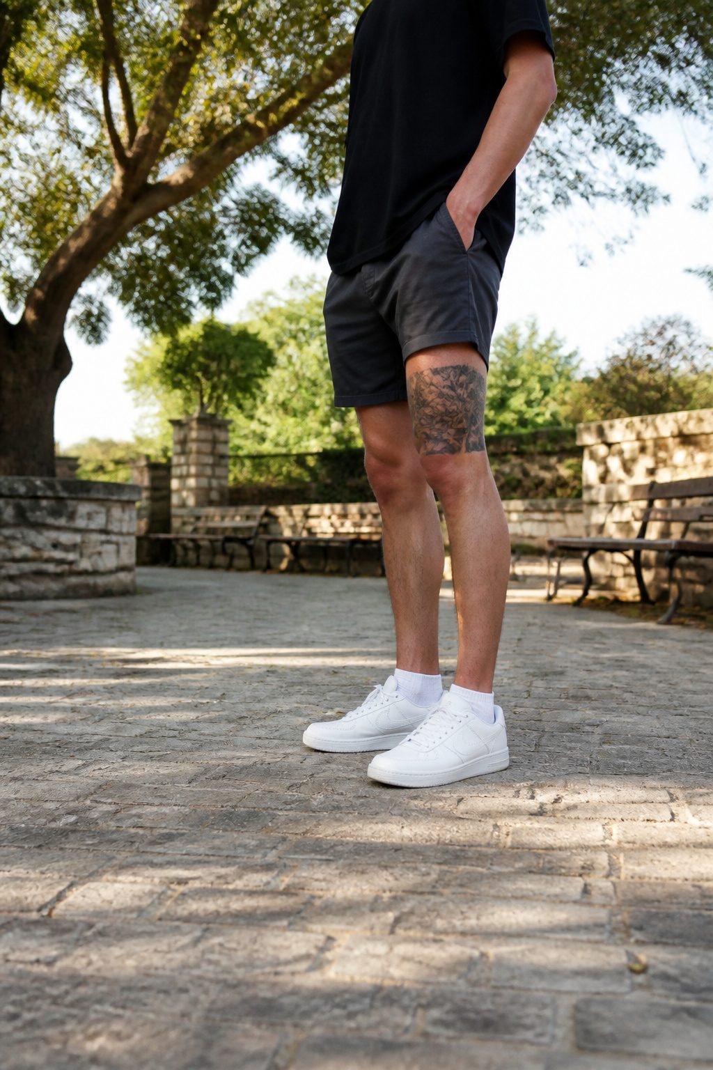 A man in shorts showing a thigh tattoo, demonstrating concealment.